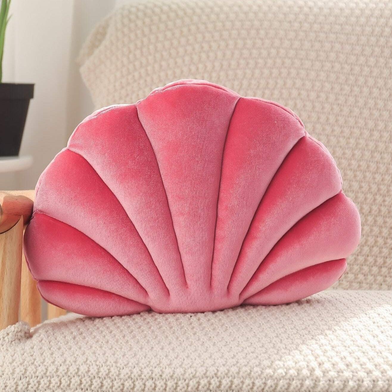 Coussin coquillage rose sur un canapé