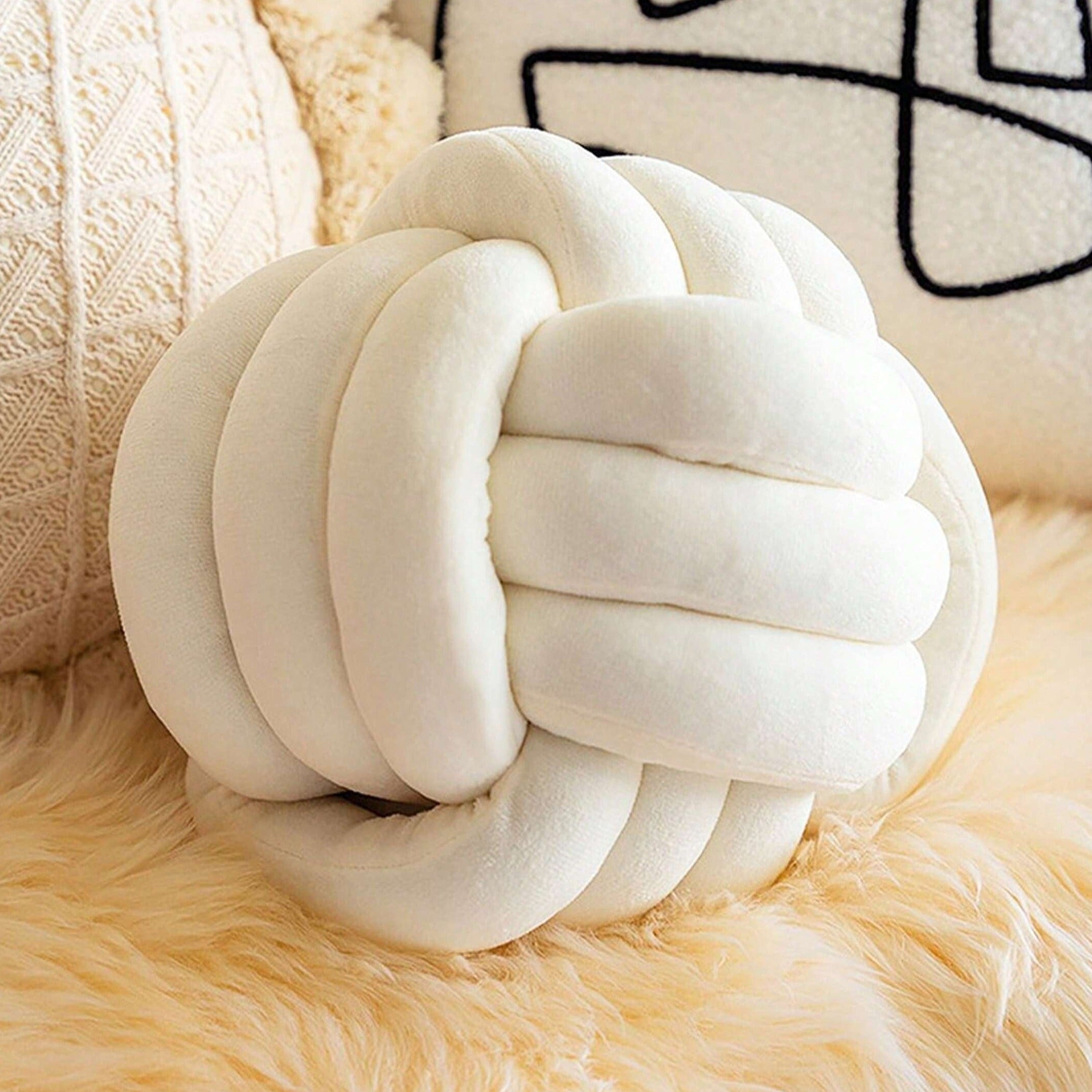 Coussin noeud blanc posé sur un canapé