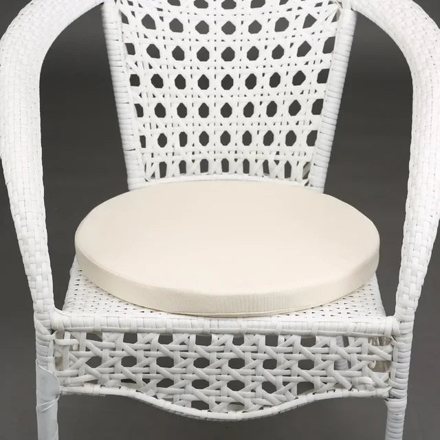 Coussin rond extérieur sur une chaise blanche