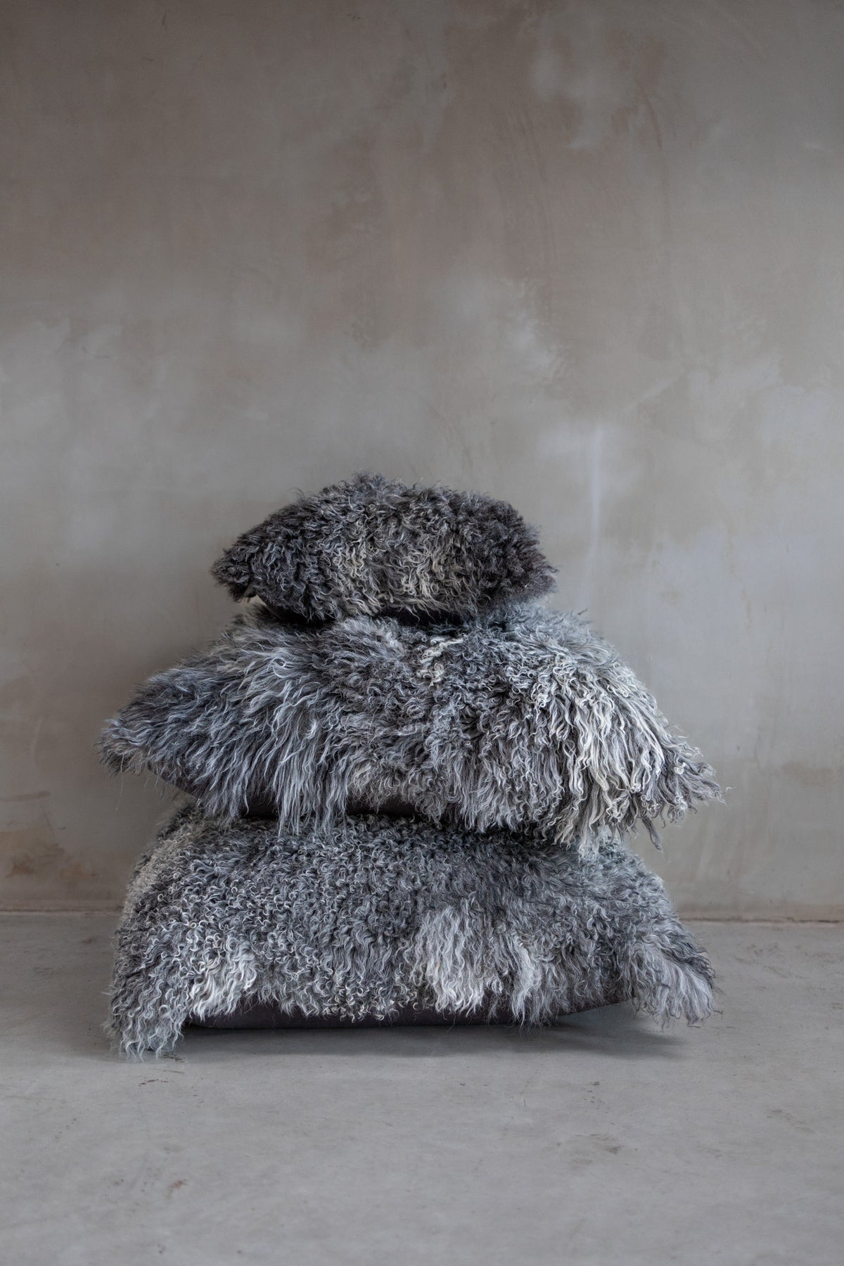 Coussin de sol en peau de mouton empilé avec des coussins assortis