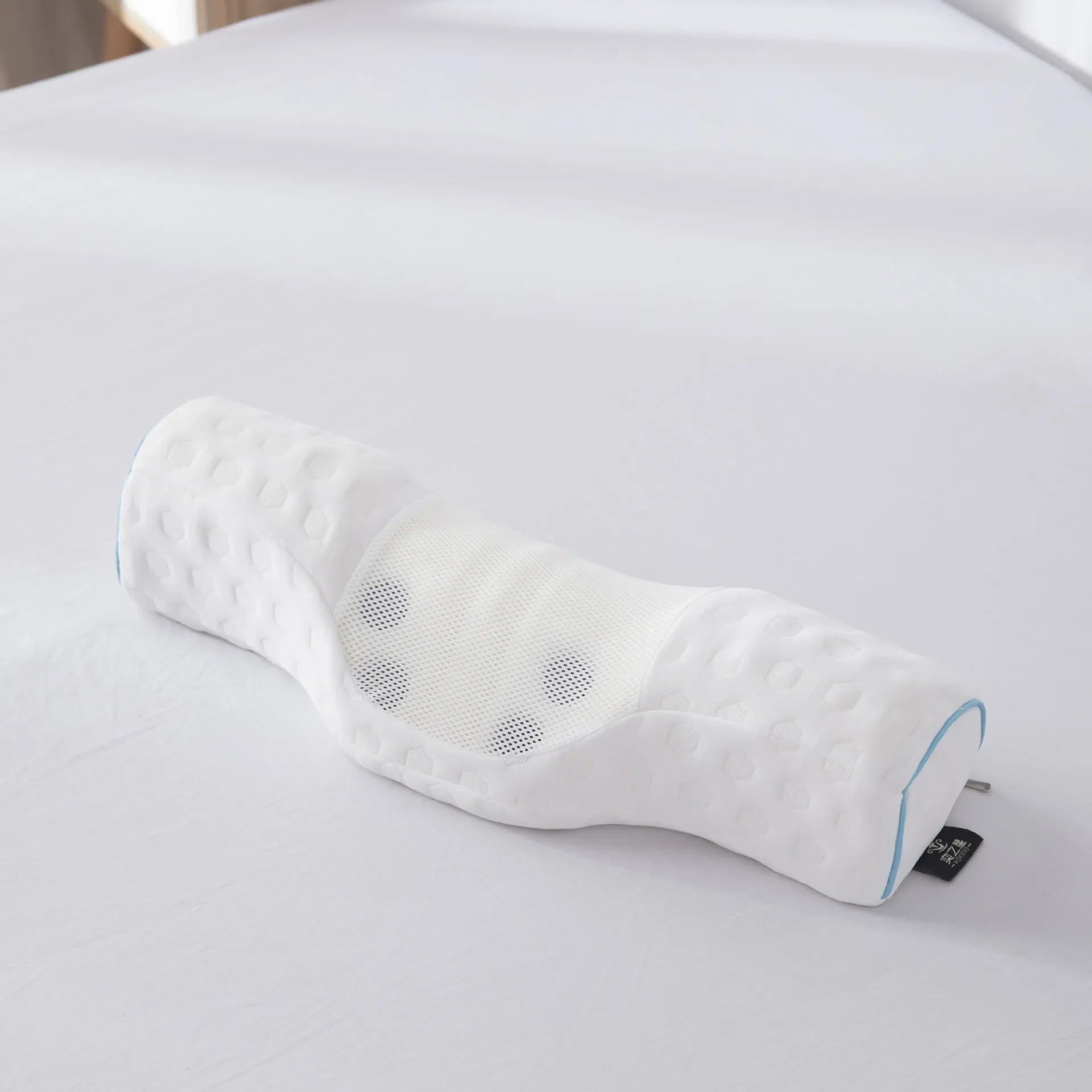 Coussin anti ronflement avec aimant à mémoire de forme sur un lit blanc