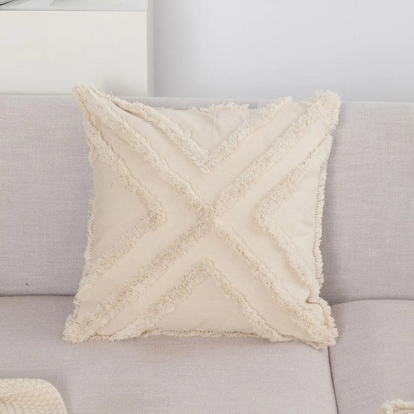 Coussin boheme chic tufté à franges sur un canapé