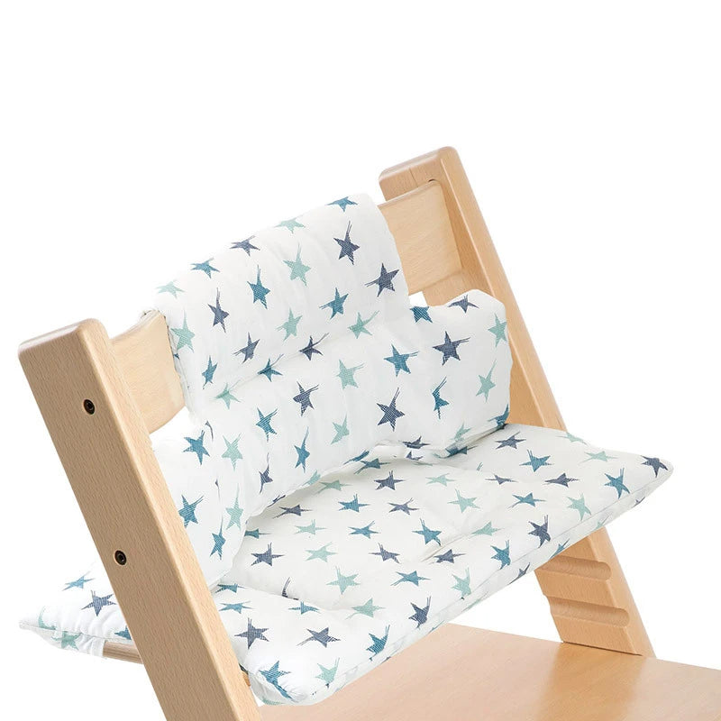 Coussin chaise haute bébé en bois avec étoiles sur une chaise en bois sur fond blanc