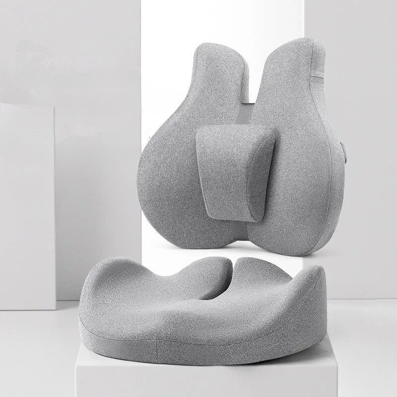 Coussin coccyx cassé avec une partie dorsale ici posé sur un support blanc.