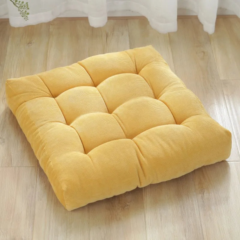 Coussin extérieur pour la méditation ici posé sur du parquet.