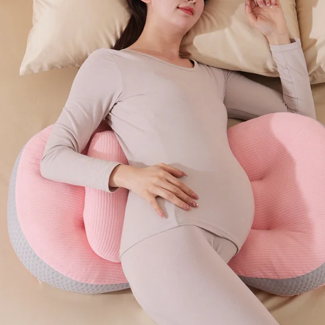 Coussin femme enceinte pour lombaires avec une femme allongée dessus sur un lit